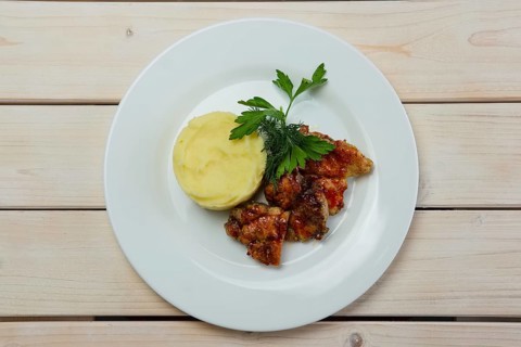Portion of delicious fried meat in honey sauce with mashed potato. Top view