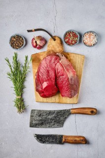 Overhead view of raw fresh deer boneless ham with spice and herb over concrete background