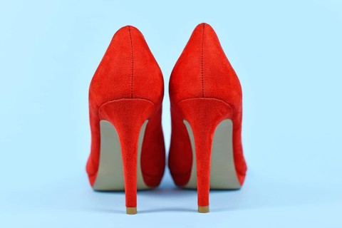 Back view of elegant red synthetic suede leather high heel woman shoes on blue background