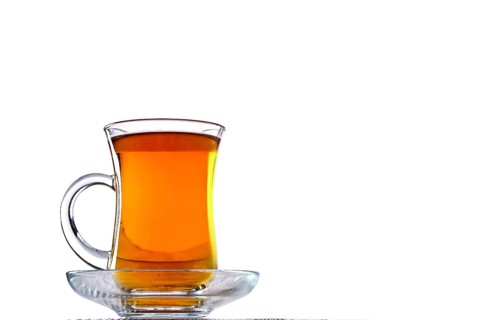 Low angle photo of cup with hot tea with copy space on white background