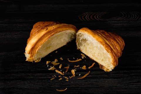 Fresh golden croissant on black table