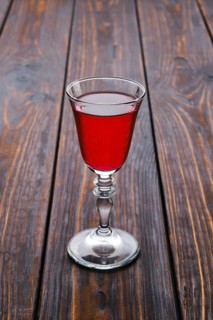 Vodka infused with berries on wooden background