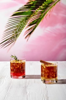 Refreshing espresso and tonic summer drinks on white table under hard sulight