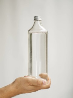 Close up hand holding water bottle mock up