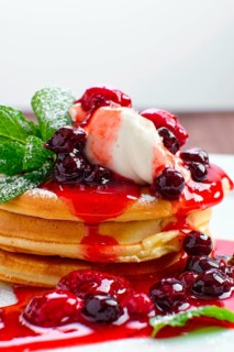 Macro photo of pancakes with strawberry and black currant jam