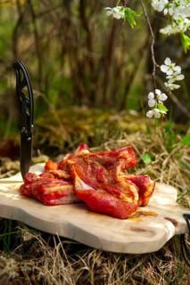 Fresh pork ribs with salt and pepper on cutting board outdoor. Selective focus photo