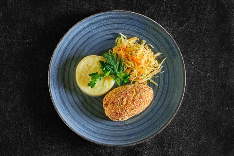 Top view of Kiev cutlet with mashed potato and pickled cabbage