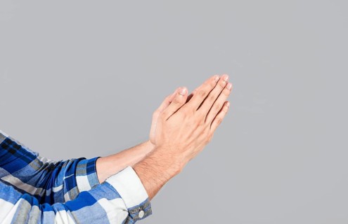 Two hands together in prayer position. Two hands together in prayer on isolated background. Concept of prayer and hands together. Two hands together thanking or asking for forgiveness