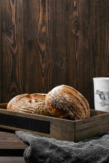 Two loafs of artisan whole grain wheat bread on wooden table