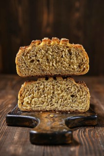 Fresh oats bread with sunflower seeds and sesame on wooden table