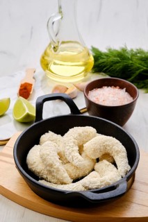 Prepared for frying uncooked shrimps in cheese breading with spice