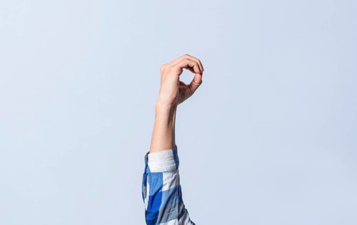 Hand gesturing the letter O in sign language on an isolated background. Man's hand gesturing the letter O of the alphabet isolated. Letter O of the alphabet in sign language
