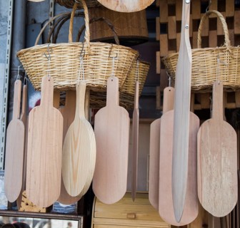 Wooden chopping boards and straw baskets hanging on display