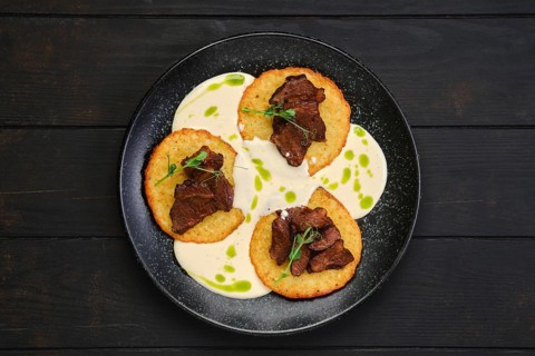 Top view of potato fritters with with fried beef slices