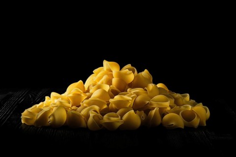 Low key photo of pipe rigate pasta. Organic whole wheat grooved pipes