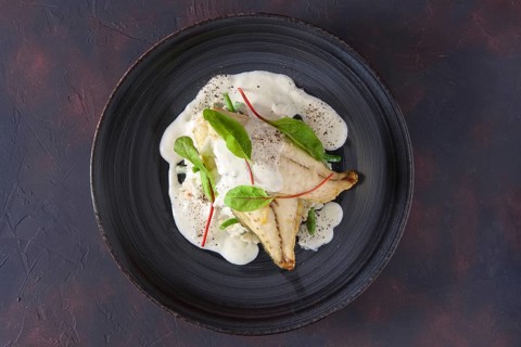Fried fillet of white fish with rice and green beans decorated with chard