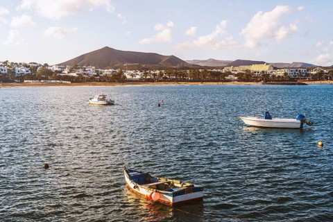 View of the resort town named Costa Teguise with boats on the foreground