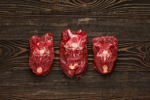 Overhead view of raw fresh deer neck over dark wooden background