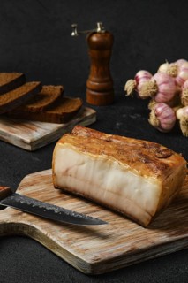 Smoked fat with brown bread on wooden cutting board