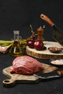 Raw beef petite sirloin with ingredients on black background