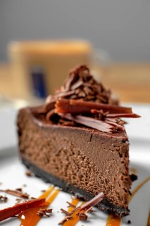 Macro photo of piece of chocolate cake with cappuccino