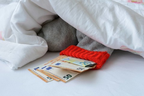Banknotes in stocking under duvet
