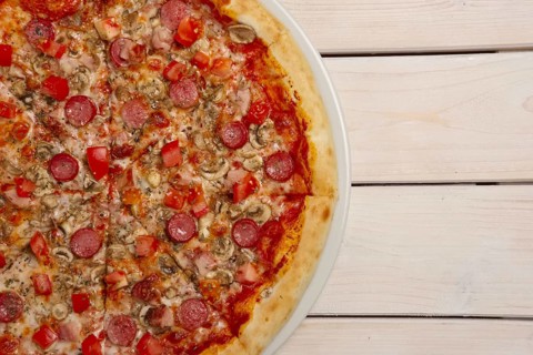 Top view of pizza pepperoni on wooden table