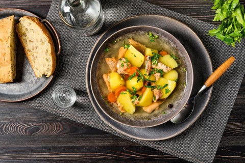 Top view of red salmon fish soup with potato and carrot