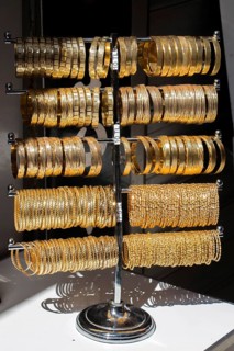 Shop display of dozens of golden bracelets and bangles