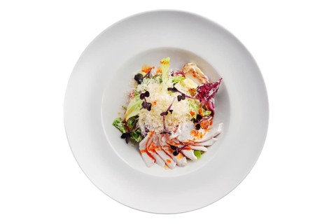 Salad with green and red cabbage and ham isolated on white background