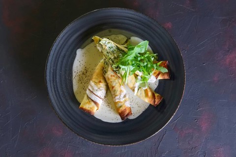 Thin pancakes stuffed with arugula and cheese
