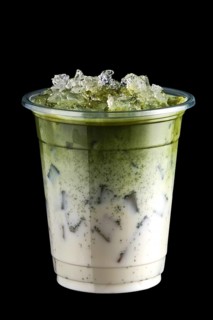 Iced matcha tea and crushed ice in take away cup isolated on black background