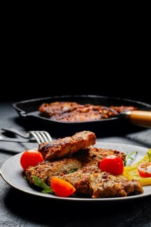 Pork chop fillet baked in oven with seasoning and herbs