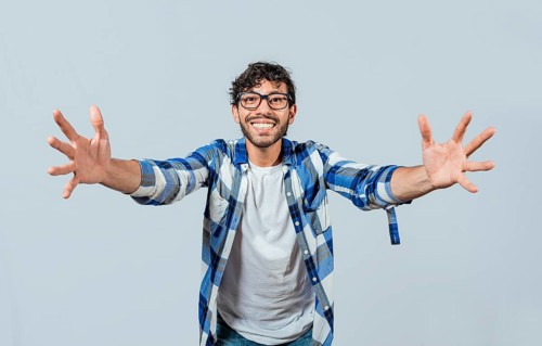Man welcoming with open arms isolated. Friendly person welcoming. Generous young man with open arms isolated