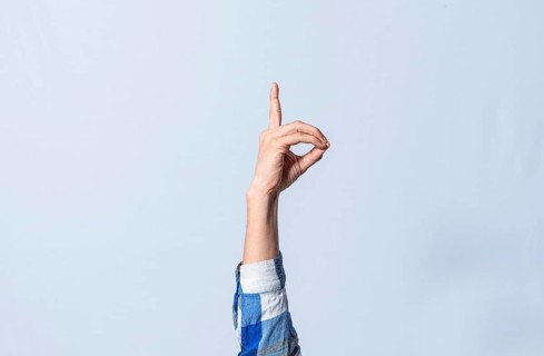 Hand gesturing the letter D in sign language on isolated background. Man hand gesturing the letter D of the alphabet isolated. Letters of the alphabet in sign language