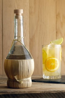 Bottle of homemade Vodka and glass witn orange juice cocktail