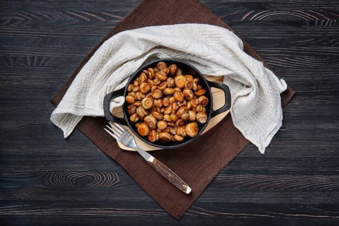 Overhead view of cast iron skillet with fried champignon with spice