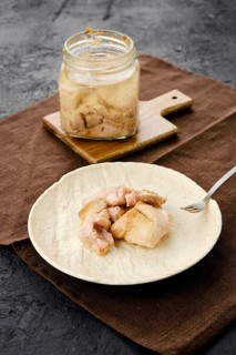 Canned cod liver in glass pot on the table