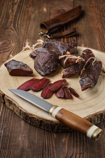 Overhead view of dried jerked deer or venison meat on wooden background