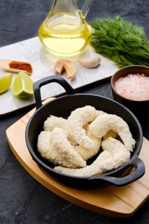 Prepared for frying uncooked shrimps in cheese breading with spice