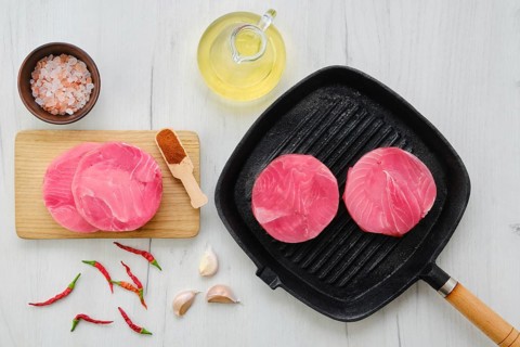 Top view of frozen round tuna cutlet for burger or frying