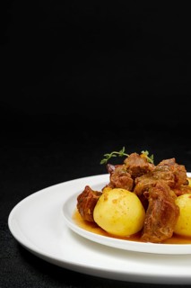 Closeup view of lamb stew with potato on a plate