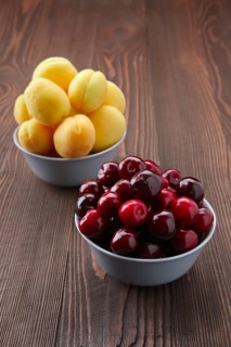 Cherries and apricots on dark wooden background