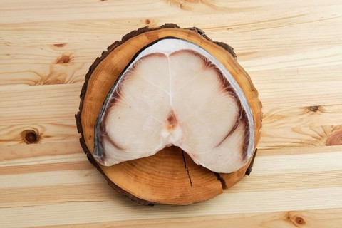 Top view of frozen blue shark steak on wooden table