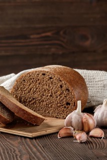 Brown garlic bread on cutting board on the table