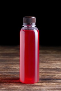 Small bottle of cranberry juice. Natural fruit-drink