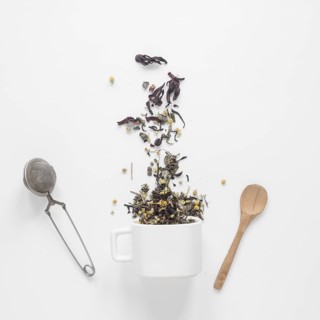 Tea herbs falling from cup with strainer spoon white backdrop. Resolution and high quality beautiful photo