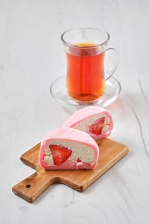Sweet dessert mochi with strawberry cut on half with fruit tea