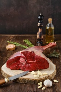 Raw fresh young beef leg on wooden background
