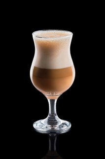 Cup of layered caramel latte isolated on black background.